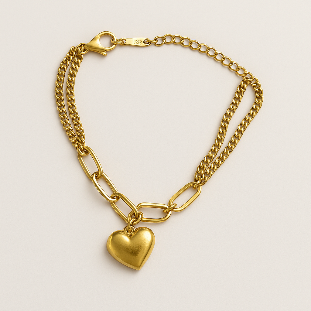 Gold chain bracelet with a heart-shaped charm on a light beige background