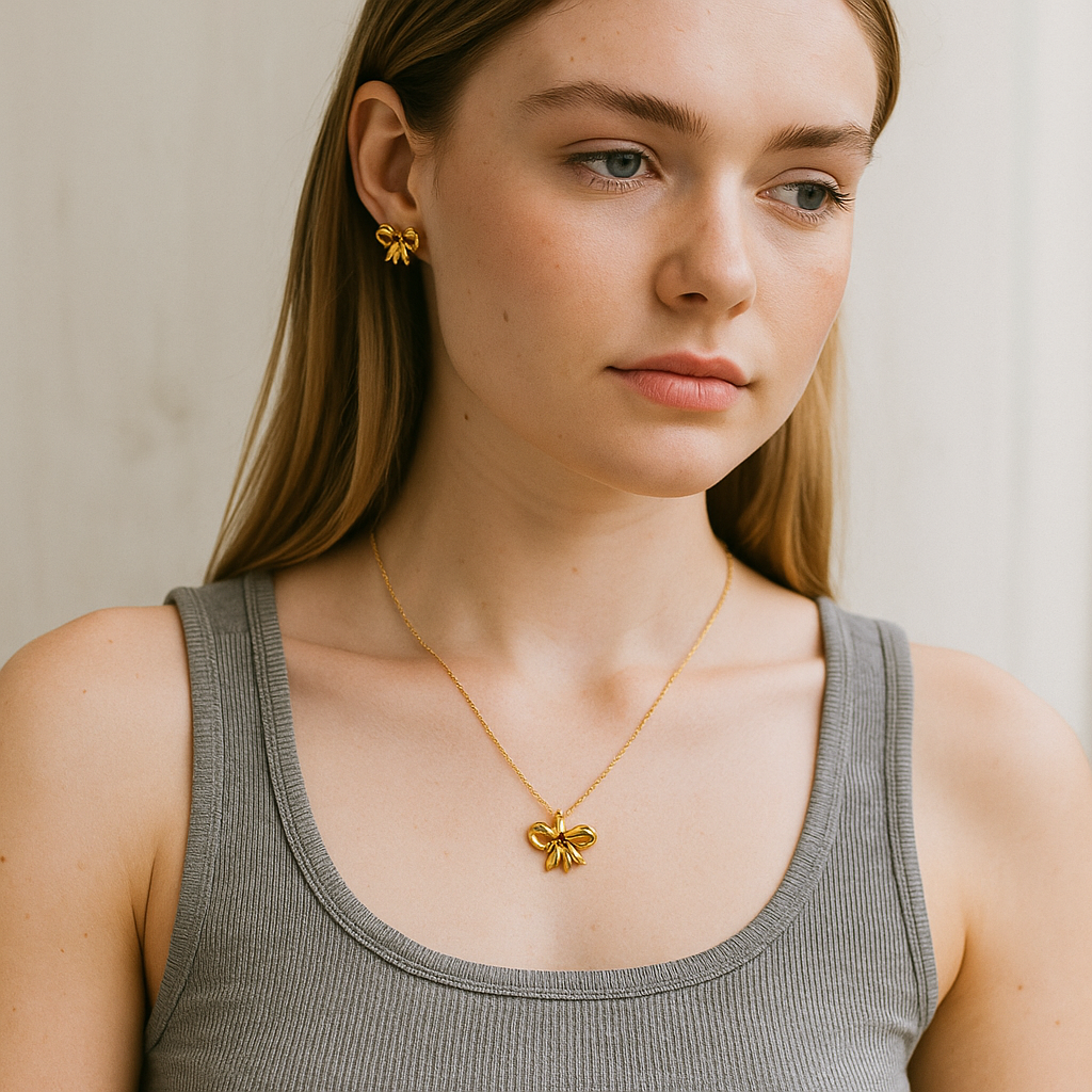 Woman wearing a gold necklace and earrings against a neutral background