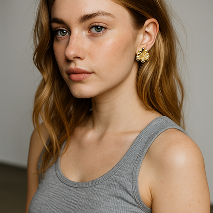 Woman wearing gold earrings with a neutral background