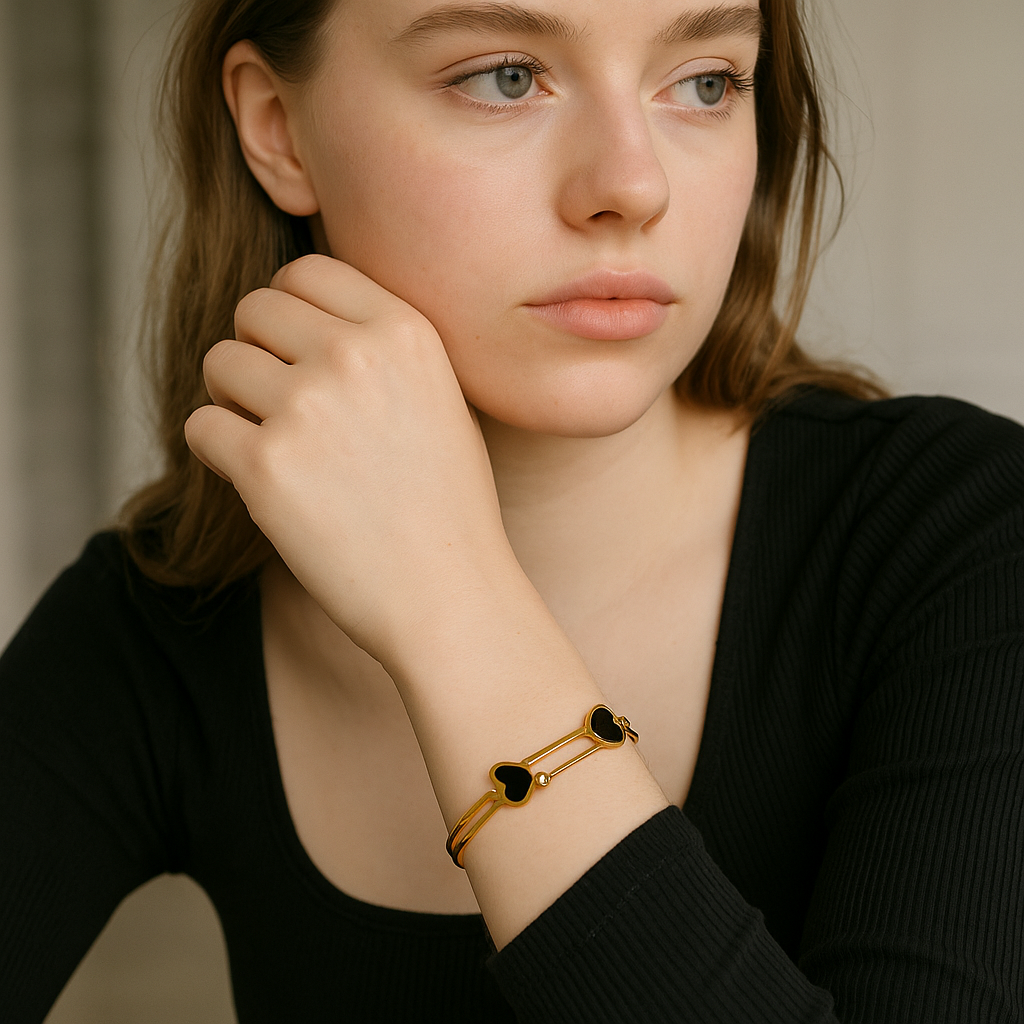 Woman wearing a 18Kt Double Cora Gold Bangle Bracelet with black stones on a neutral background