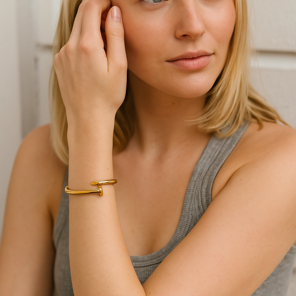 Woman wearing a 18kt gold nail bracelet, close-up of arm and hand.
