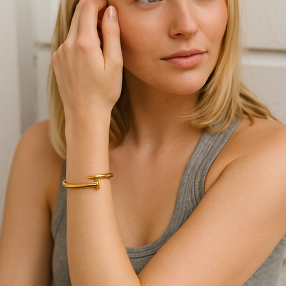 Woman wearing a 18kt gold nail bracelet, close-up of arm and hand.