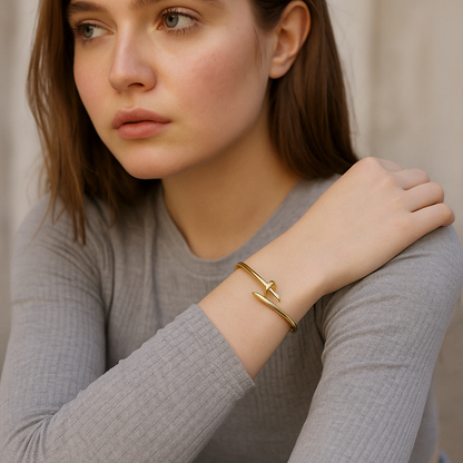 Woman wearing a 18kt gold nail bracelet on a neutral background