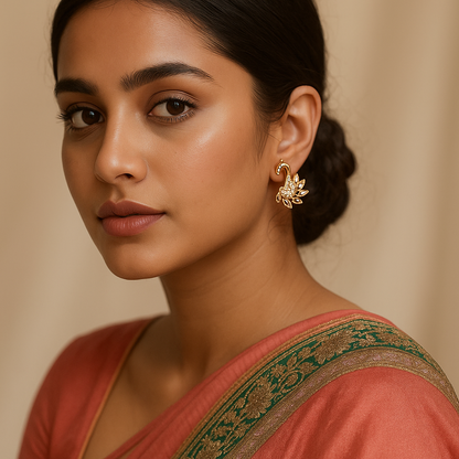 Woman wearing a traditional saree with a gold earring against a beige background