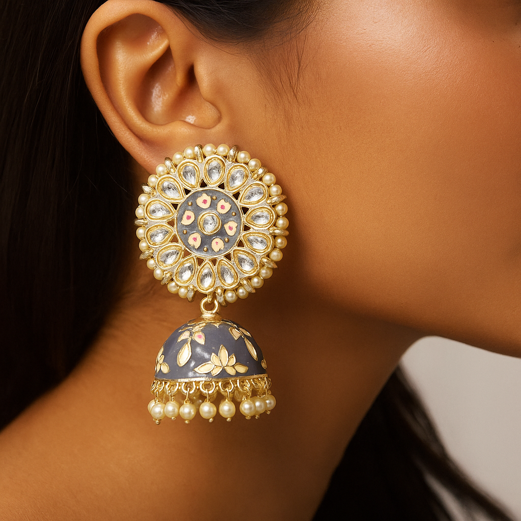 Close-up of a person wearing an ornate gold and blue Indian Pakistani Jhumka earring with pearl accents.