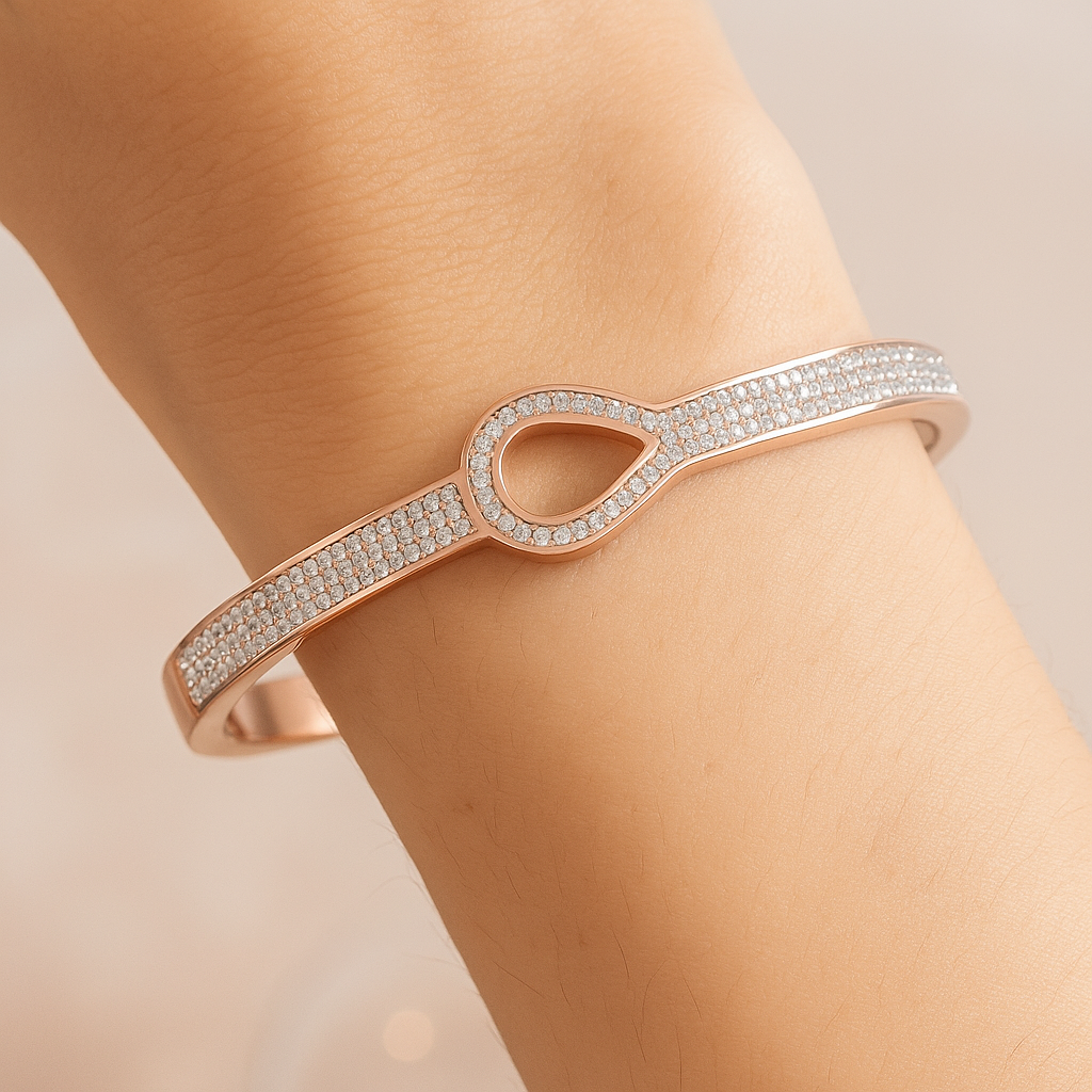 Rose gold bracelet with diamond accents on a wrist against a neutral background