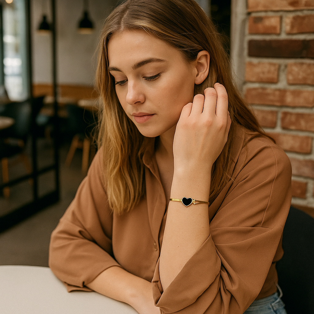 Woman adjusting her earring in a casual setting with a brick wall background