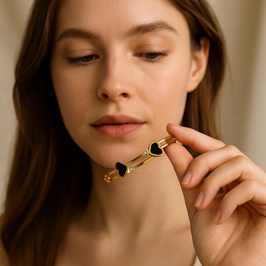 Woman holding a gold hair clip with heart details against a neutral background