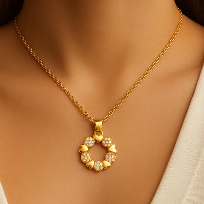 Gold necklace with a circular pendant on a person wearing a beige top.