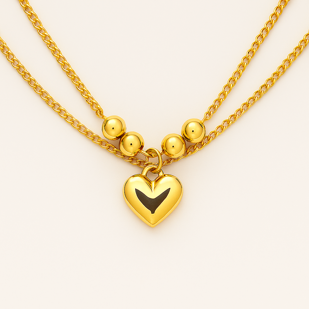 Gold necklace with a heart-shaped pendant on a light background