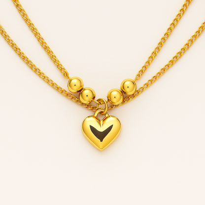 Gold necklace with a heart-shaped pendant on a light background