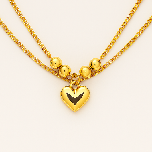 Gold necklace with a heart-shaped pendant on a light background