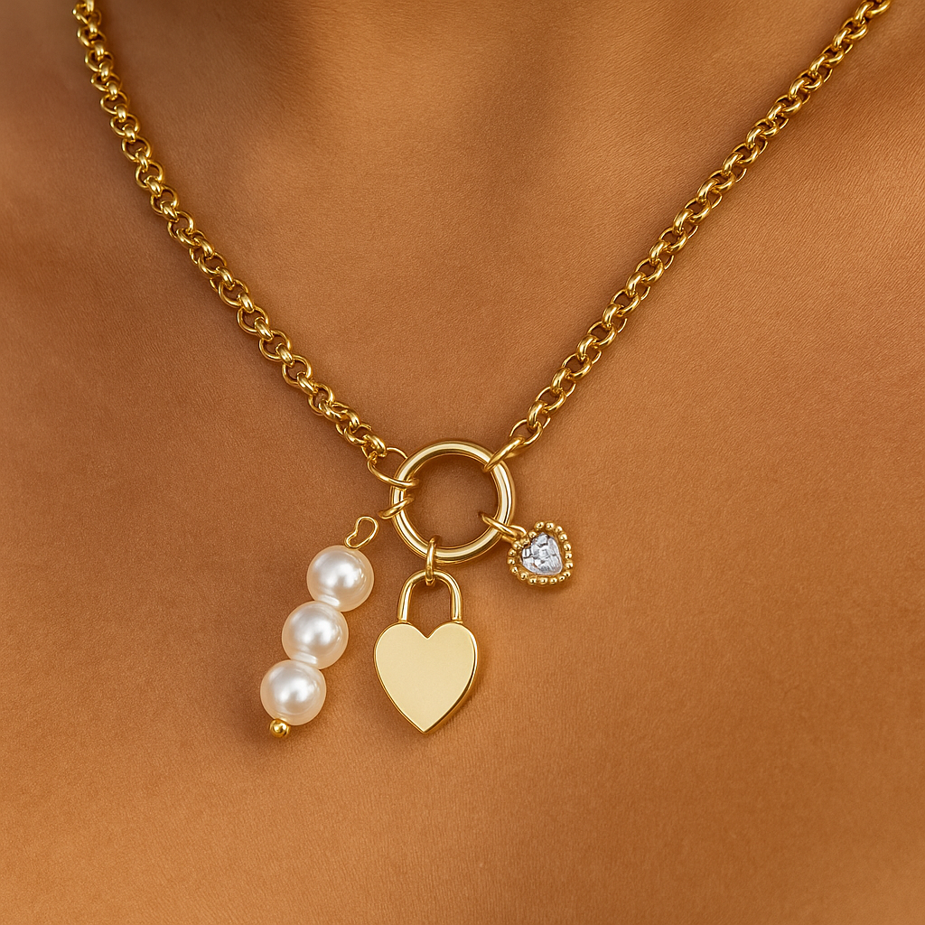 Gold necklace with heart, pearl, and round charm on a brown background