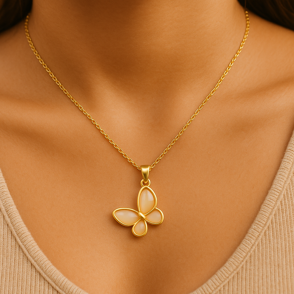Gold butterfly pendant necklace on a person wearing a beige top