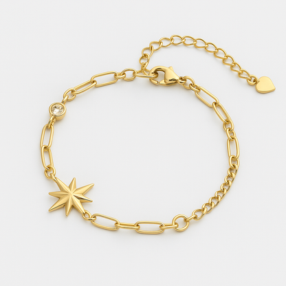 Gold bracelet with star charm on a light gray background