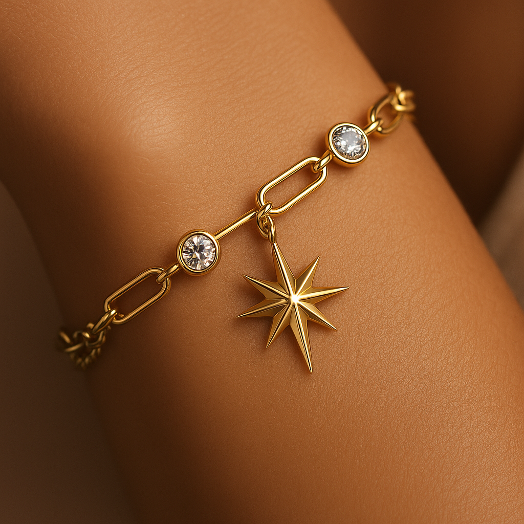 Gold bracelet with star charm on a wrist against a neutral background