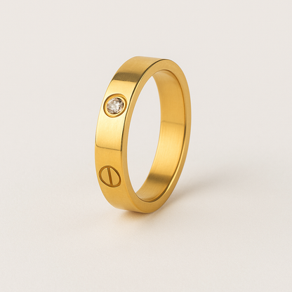 Gold ring with a small diamond on a light beige background
