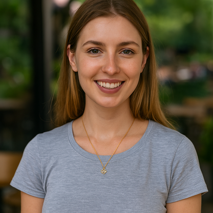 Woman wearing a gray shirt with a blurred green background with purple necklace