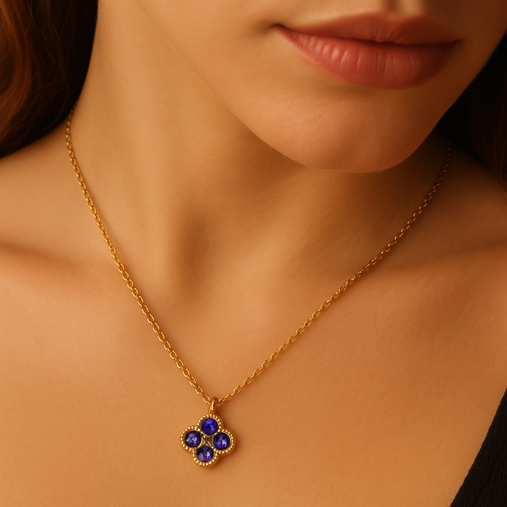 Gold necklace with a blue pendant worn by a person