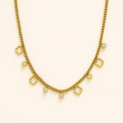 Gold necklace with clover-shaped charms on a beige background