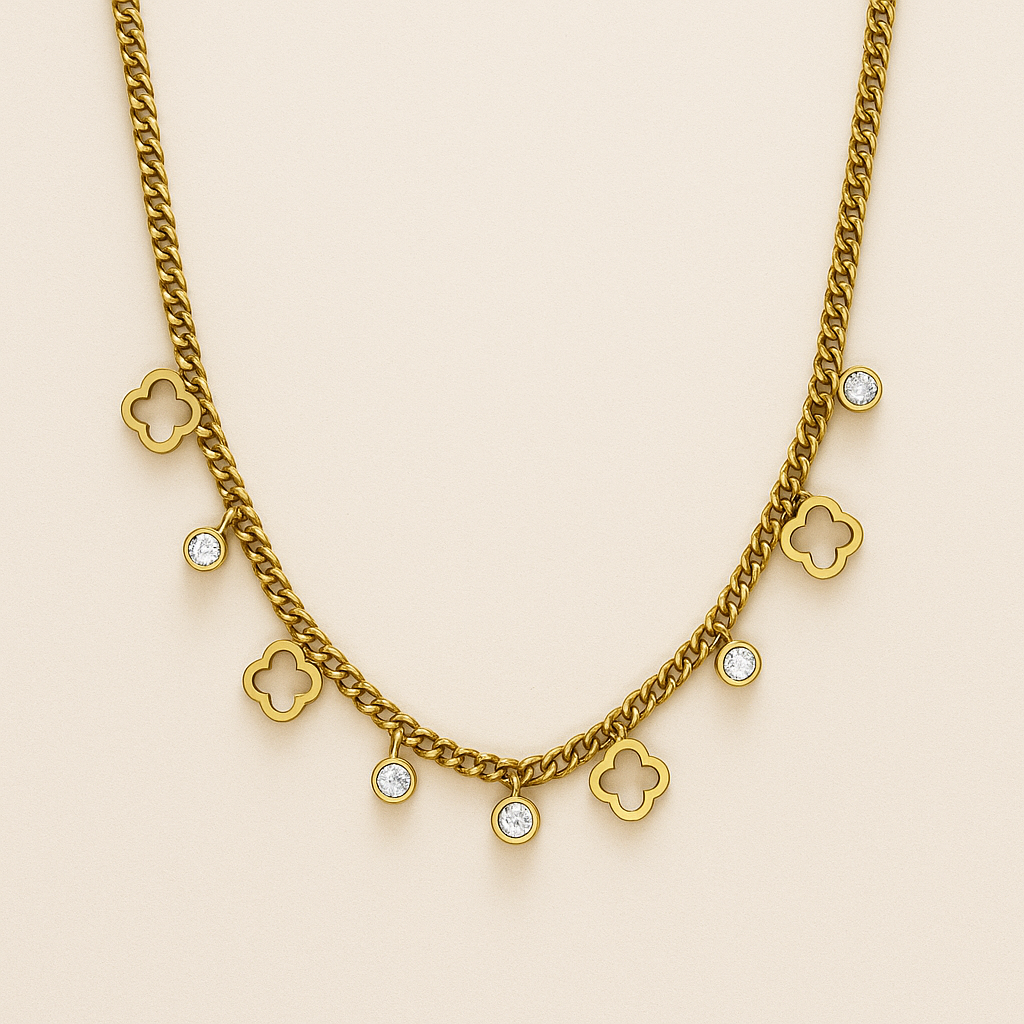 Gold chain necklace with clover and diamond-like pendants on a beige background