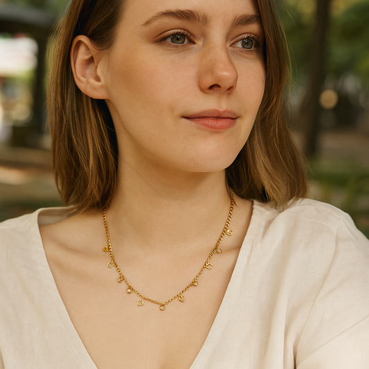 Woman wearing a gold necklace with a blurred outdoor background