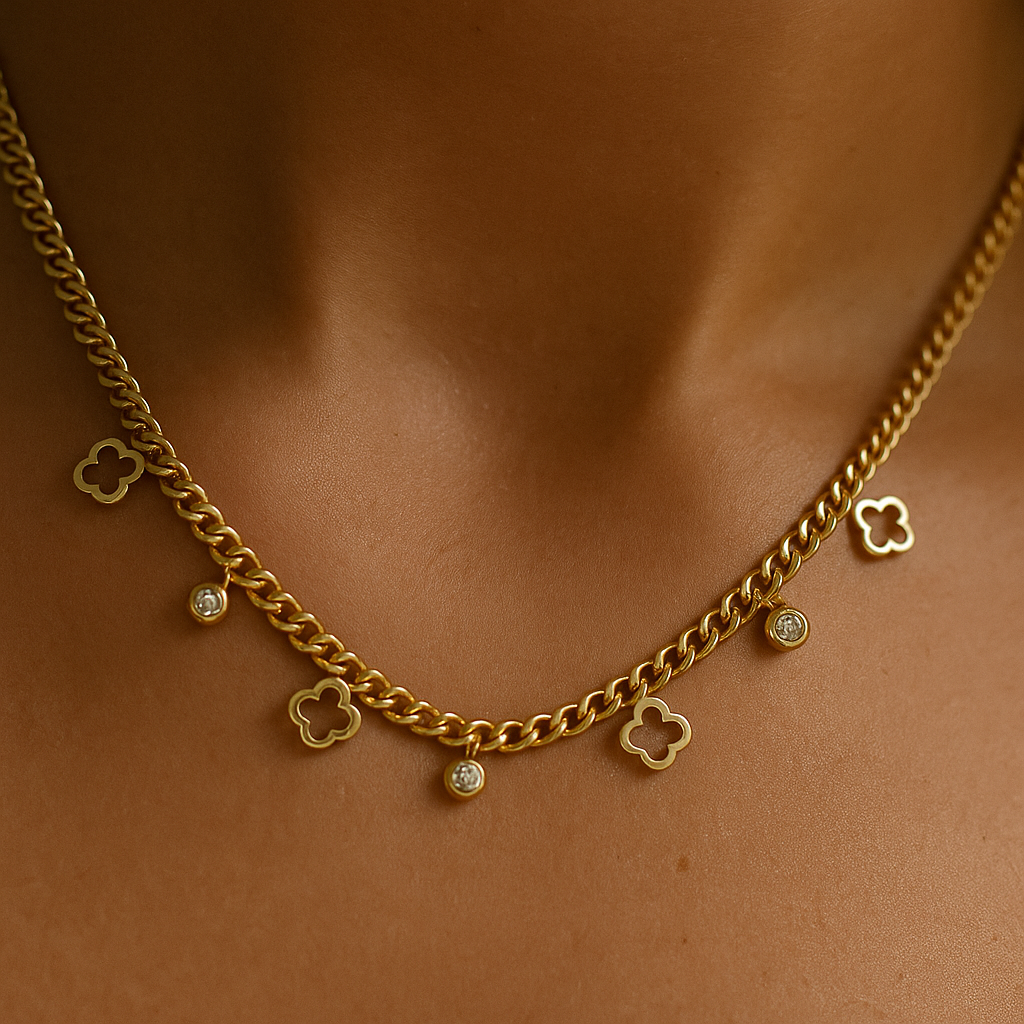 Gold chain necklace with clover-shaped charms on a person's neck against a brown background