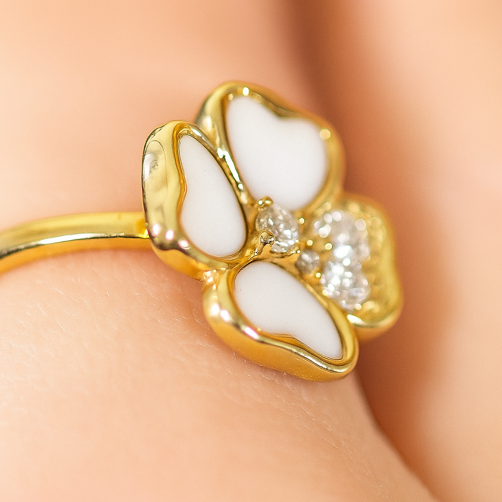 Gold ring with white stones on a person's finger