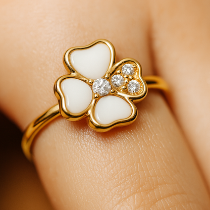 Gold ring with white butterfly design and clear gemstones on a skin background