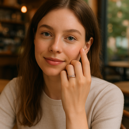 Woman with a soft smile and hand near her face in a warm-toned indoor setting