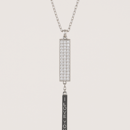 Silver necklace with rectangular pendant and 'I LOVE YOU' bar on a light gray background