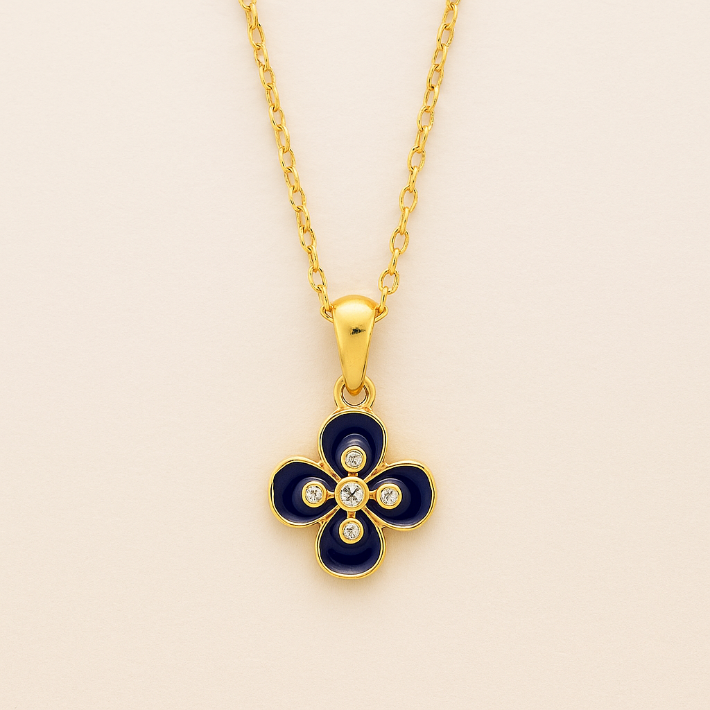 Gold necklace with a blue clover-shaped pendant on a beige background