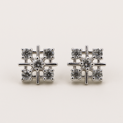 Pair of silver earrings with gemstones on a light background