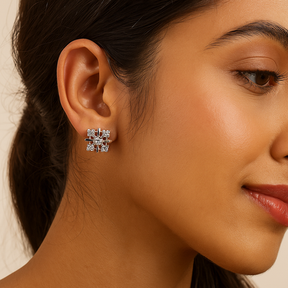 Close-up of a woman wearing diamond stud earrings with a neutral background