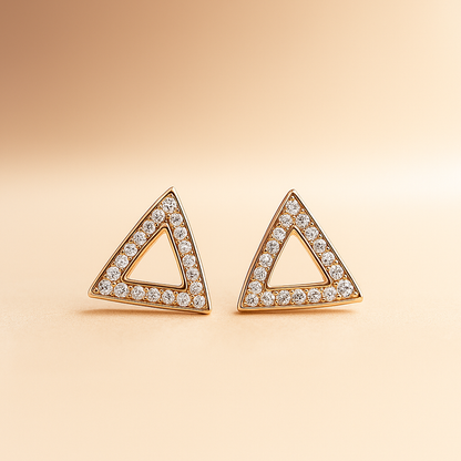 Triangle-shaped earrings with diamond accents on a beige background