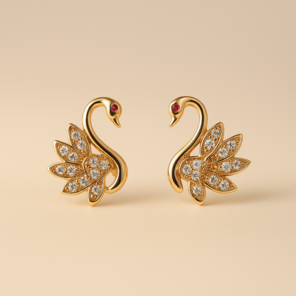 Gold swan earrings with gemstones on a beige background