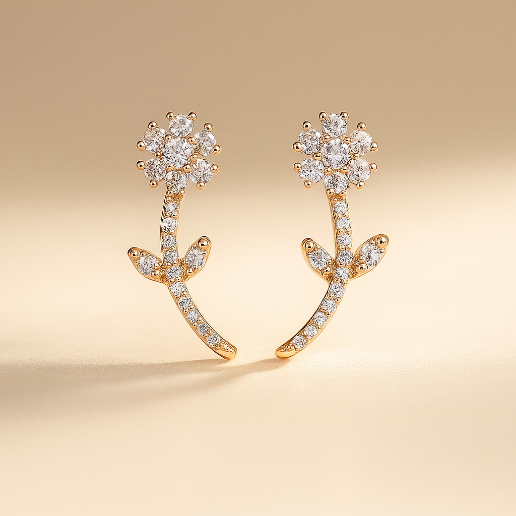 Gold earrings with diamond-like stones on a beige background