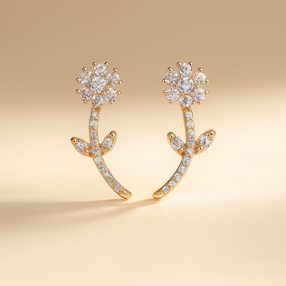 Gold earrings with diamond-like stones on a beige background