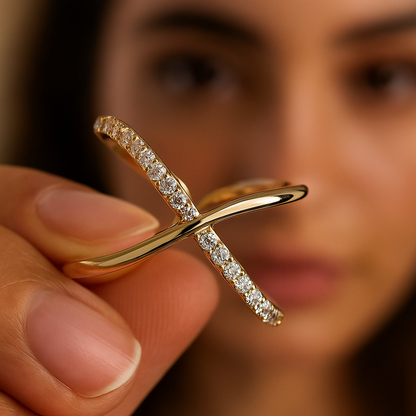 Gold ring with diamonds held by a person against a blurred background