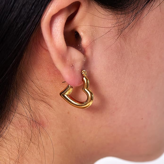 A close-up image of a person wearing a gold hoop earring, focusing on the jewelry against the ear.