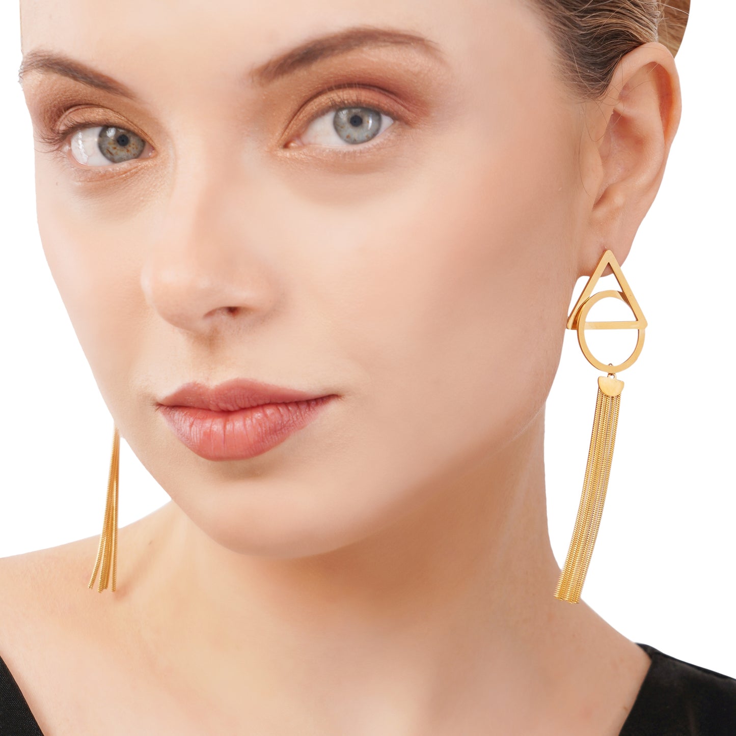 A woman wearing long gold statement earrings with a geometric design and a chain link drop.