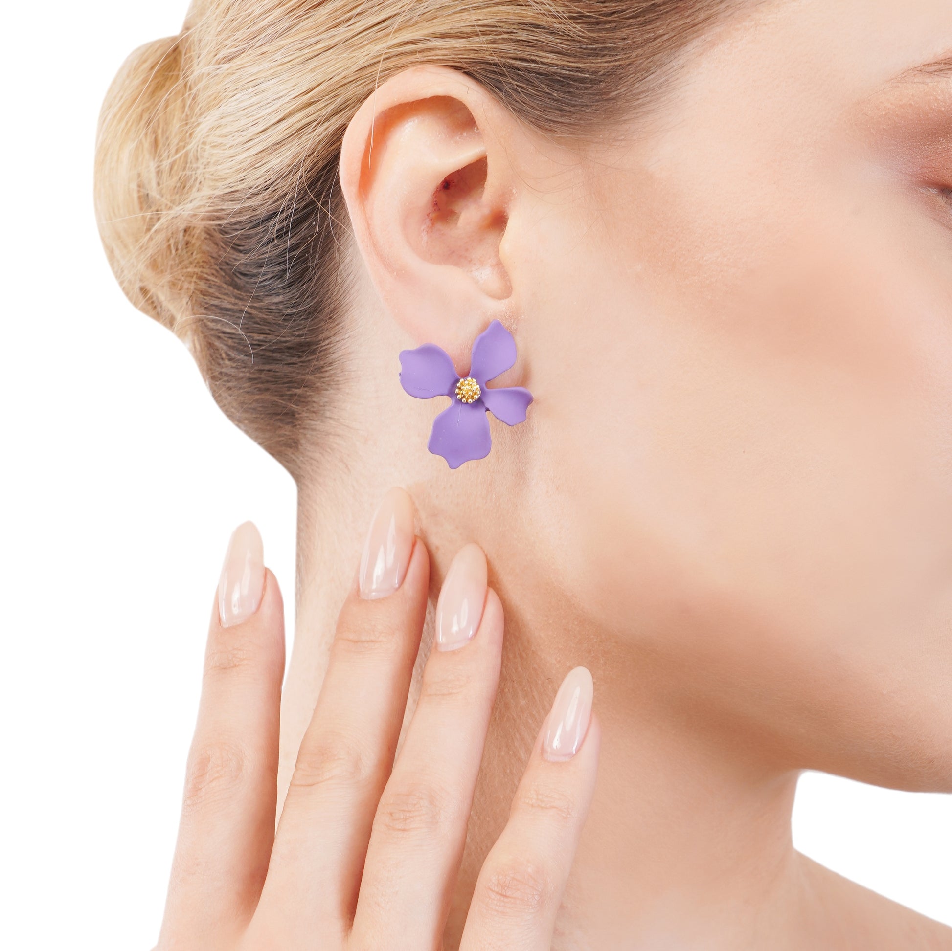 This image features an elegant purple flowery stud earring, showcased on a woman’s ear. The earring is designed with a simple yet captivating floral motif, rendered in a striking purple color with a central golden yellow motif, possibly representing the flower's core.