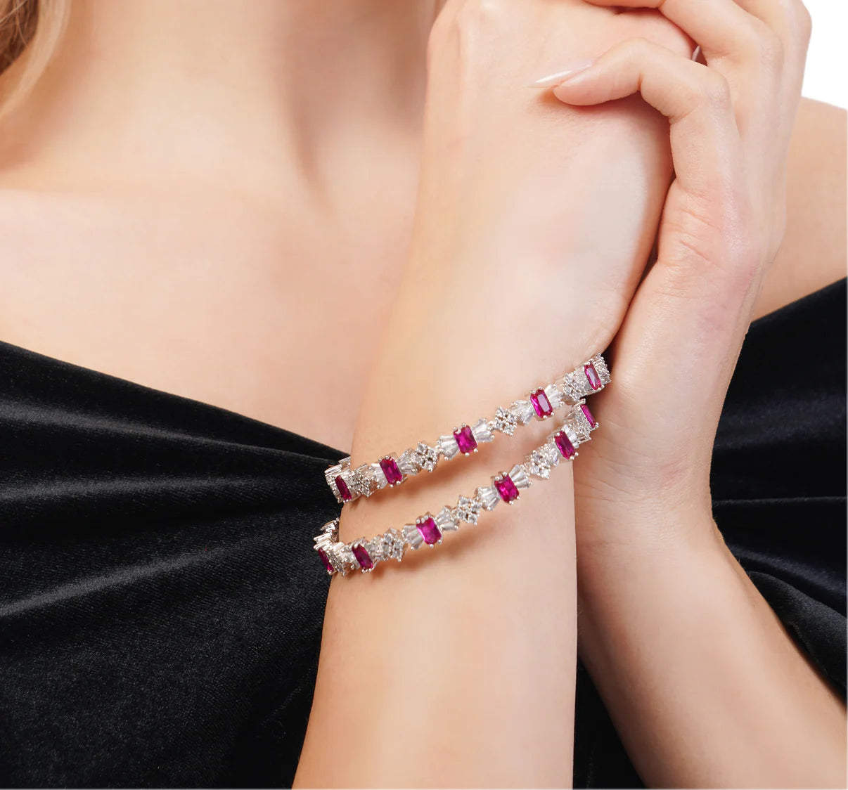 Bracelet with red gemstones on a person's wrist against a black background