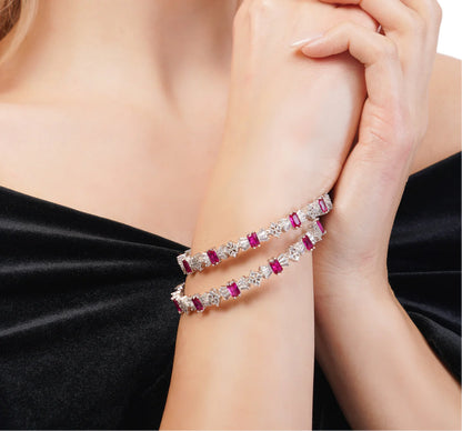 Bracelet with red gemstones on a person's wrist against a black background