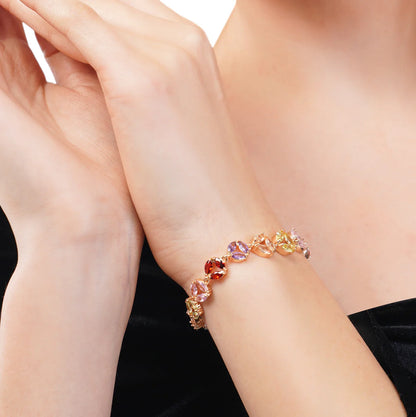 Multicolored gemstone bracelet on a person's wrist against a black background