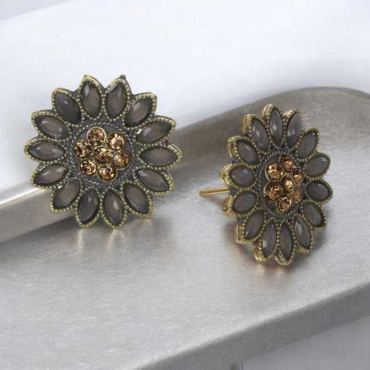 A pair of floral gray stud earrings with a sunflower design, featuring kundan earring styles with gold accents.