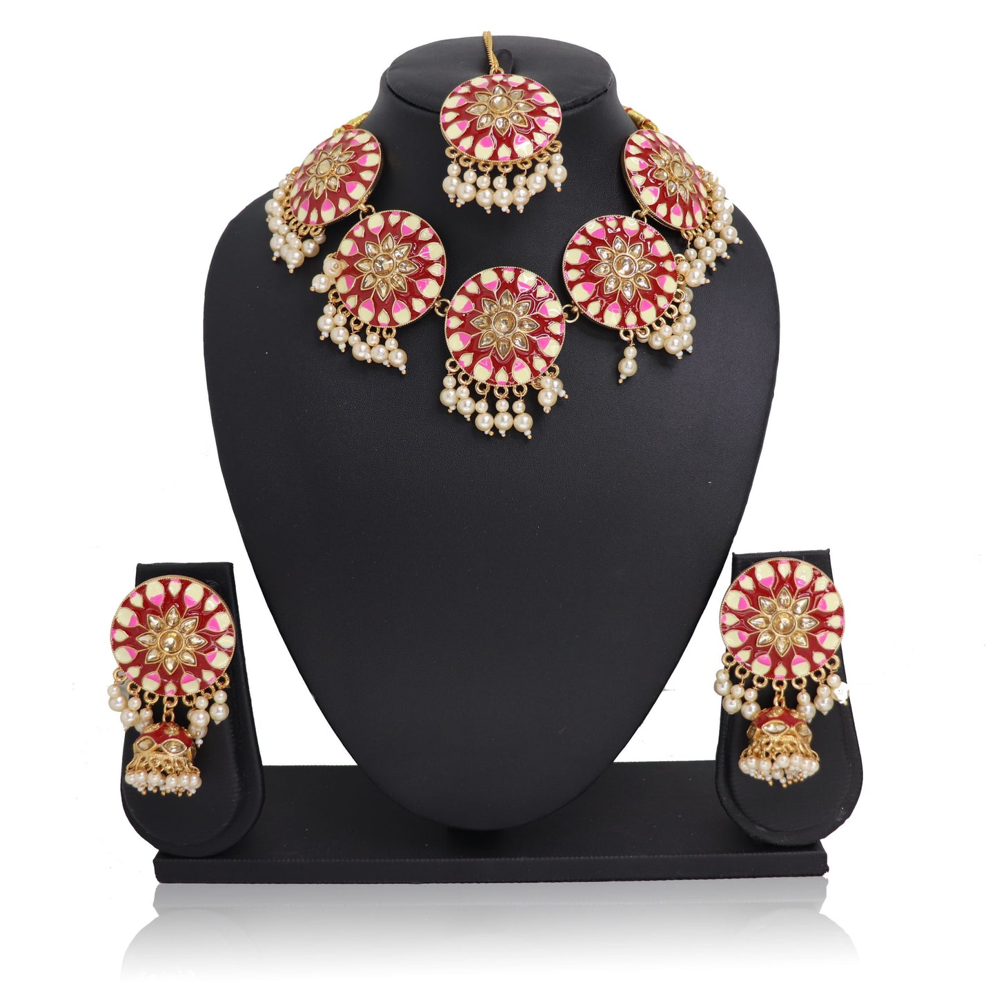 A red-pink choker necklace set with gold-colored accents and pearls, displayed on a mannequin.