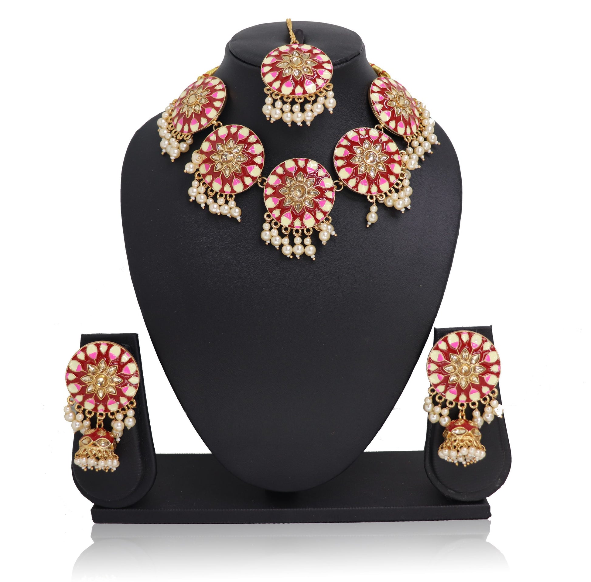 A red-pink choker necklace set with gold-colored accents and pearls, displayed on a mannequin.