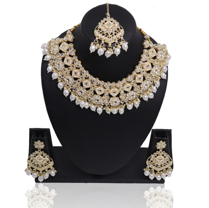A pearl necklace set with a similar design in Bridal earrings displayed on a mannequin bust, predominantly in gold and white colors.