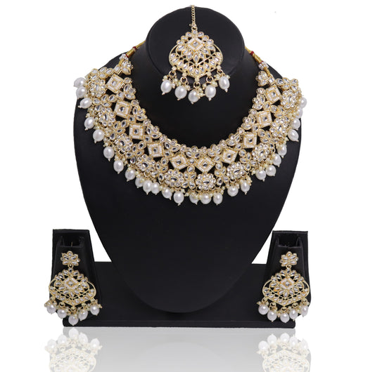 A pearl necklace set with a similar design in Bridal earrings displayed on a mannequin bust, predominantly in gold and white colors.